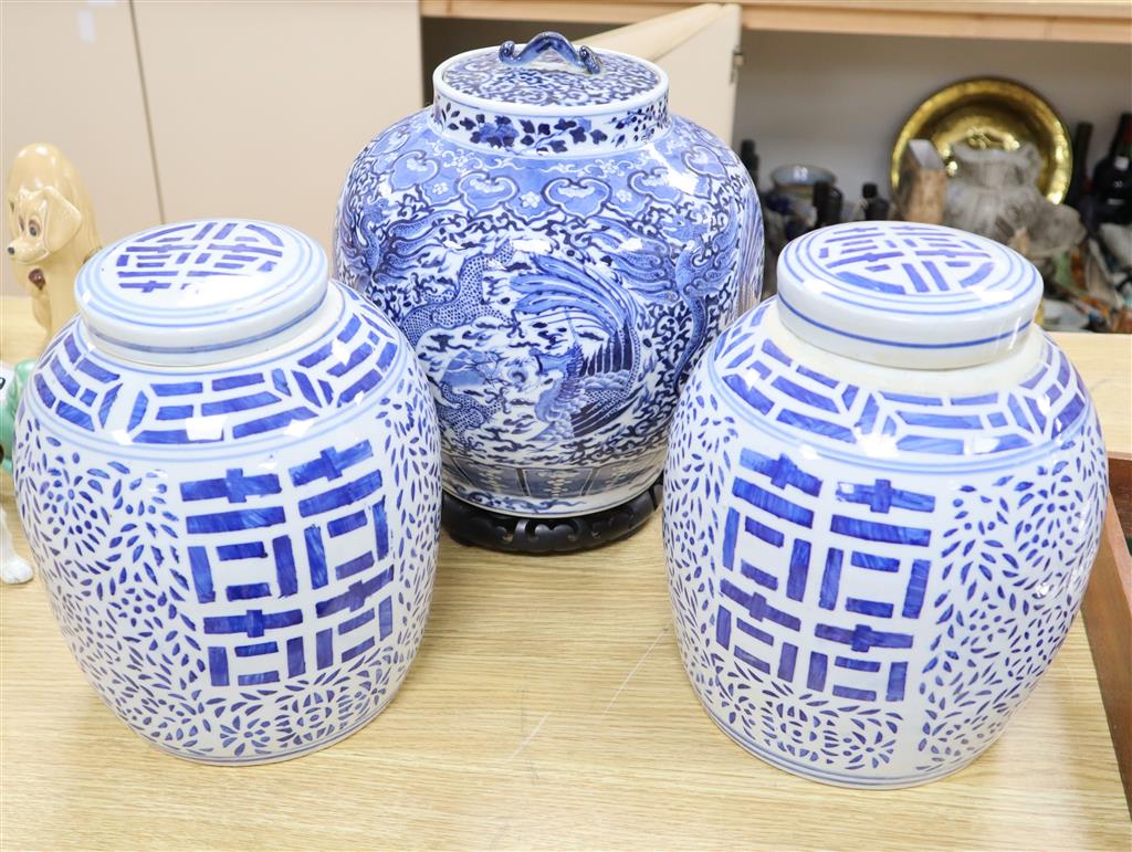 A 19th century blue and white water jar and cover, painted with dragons and birds, with inner cover and two later jars and covers